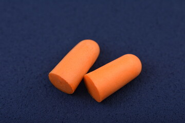 Ear plugs isolated on blue /dark background.Orange   ear plugs isolated
