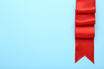 Naklejka premium Beautiful red ribbon on light background, top view. Space for text