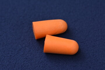 Ear plugs isolated on blue /dark background.Orange   ear plugs isolated
