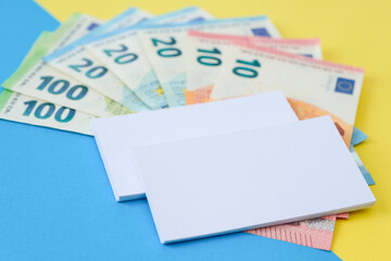 Two business cards and euro money on a colour backrgound