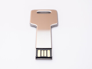 Silver usb flash drive in the form of a key on a white background