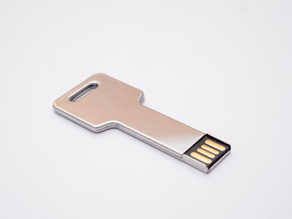 Silver usb flash drive in the form of a key on a white background