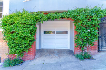 Small concrete driveway with white front door and white garage door with glass in San Francisco, CA