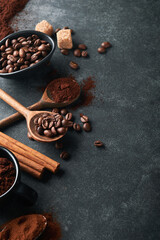 Coffee beans background. Roasted Coffee concept with differents types of coffee, beans and cinnamon sticks on dark black stone background. Top view. Coffee concept. Mock up.