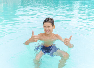 Happy child boy  in swimming pool. Summer vacation concept.