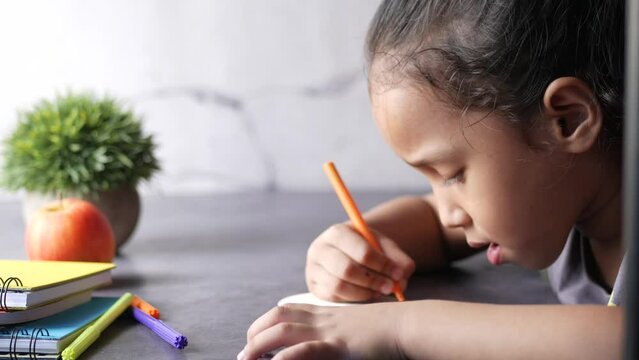 child girl drawing on paper on table sice view 