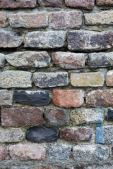 The rough textured surface of the wild stone wall. Background.