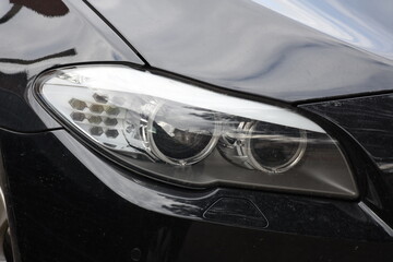 Obraz na płótnie Canvas Car's exterior details.Blue car - headlight on a black car