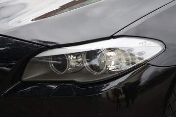 Obraz na płótnie Canvas Car's exterior details.Blue car - headlight on a black car