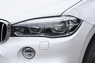 Fototapeta na wymiar shiny headlight on a gray car