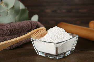 Tooth powder, brush and towel on wooden table, closeup