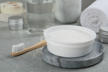 Fototapeta na wymiar Tooth powder and brush on light grey marble table, closeup
