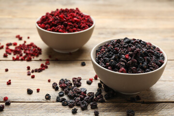 Dried red and black currant berries on wooden table