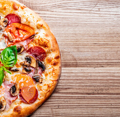 pizza with Mozzarella cheese, ham, mushrooms, salami. Italian pizza on wooden table background