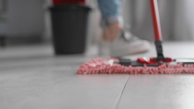 Close up of caucasian woman mopping the floor at home. Shot with RED helium camera in 8K.    