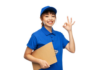 profession, job and people concept - happy smiling delivery woman in blue uniform with clipboard showing ok gesture over white background