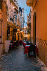 Fototapeta na wymiar Illuminated alley in Ortigia with restaurant tables set up