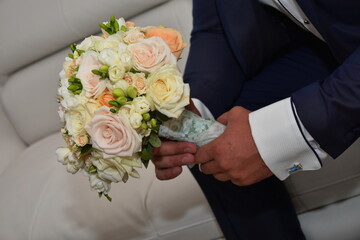 Obraz na płótnie Canvas groom holding wedding bouquet