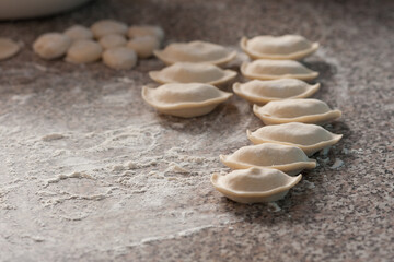 Fototapeta na wymiar Preparation of traditional Ukrainian dishes. The process of hand molding dumplings at home.