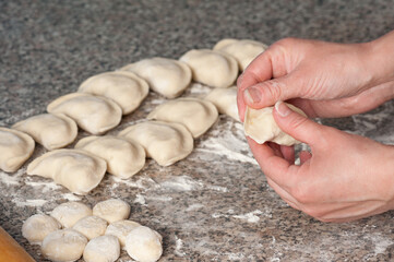 Preparation of traditional Ukrainian dishes. The process of hand molding dumplings at home.