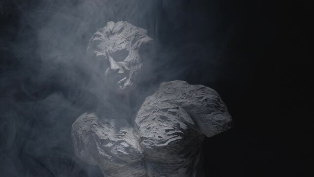A white statue of a man. A close-up shot on a black background.