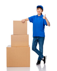 mail service and shipment concept - happy smiling delivery woman with parcel boxes in blue uniform over white background