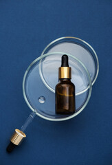 Amber glass dropper bottle, blue background. SPA, Aromatherapy and perfume concept