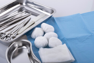 Medical equipment with dressing material in kidney-shaped tray.