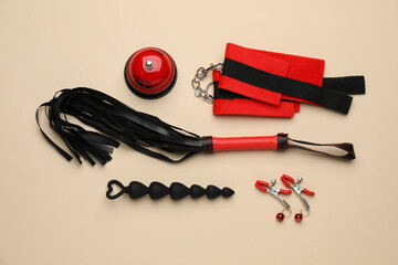 Sex toys and accessories on beige background, flat lay