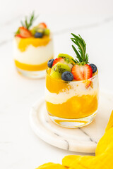 Delicious healthy breakfast, mango smoothie with natural yogurt and blueberries and strawberries with kiwi