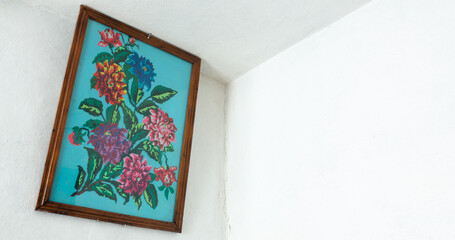 Embroidered picture with threads. Image of flowers. hanging in the room