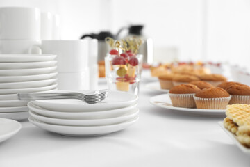 Table with different delicious snacks and dishware indoors. Coffee break