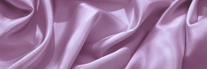Pink purple silk satin. Wavy folds. Silky shiny fabric. Elegant lilac background with space for design. Web banner. Website header. Panoramic.