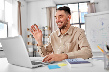 distant education, school and remote job concept - happy smiling male teacher with laptop computer having online class or video call at home office