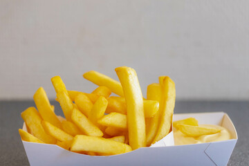 Selective focus of french fries in white paper box on the table, Friet or Patat served with...