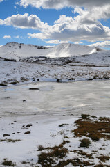 A frozen lake surrounded by early autumn snowfall on the mountains around Independence Pass, Colorado, USA