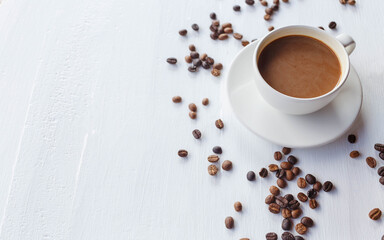 coffee cup and coffee beans on white wooden background