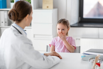 medicine, healthcare and pediatry concept - female doctor or pediatrician and coughing little girl patient on medical exam at clinic