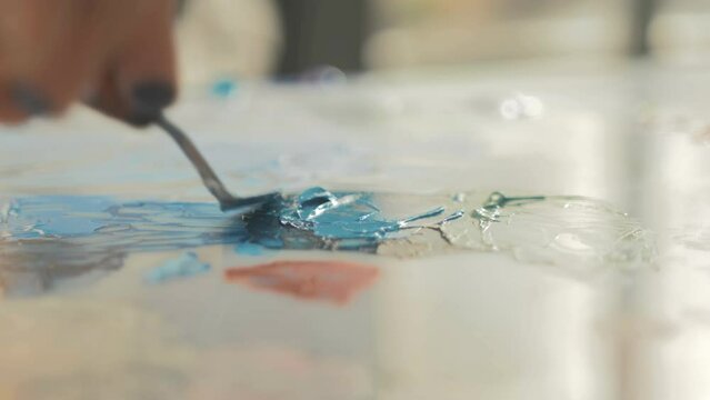 Painter mixing acrylic colors with palette knife. Slow Motion