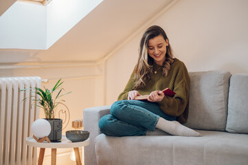 Woman at home sitting on a couch and reading a book