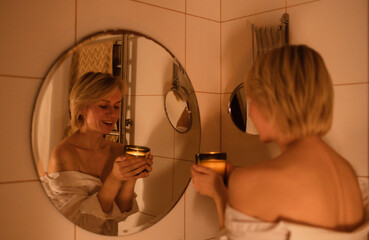 Close up portrait of attractive young woman standing in bathroom. Lifestyle and health concept....
