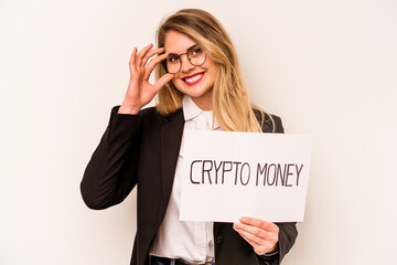 Young business caucasian woman holding a crypto money placard isolated on white background excited keeping ok gesture on eye.