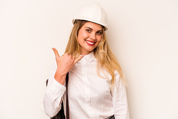 Young architect woman with helmet and holding blueprints isolated on white background showing a mobile phone call gesture with fingers.