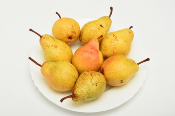 yellow pear on a plate on white background
