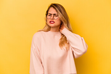 Young caucasian woman isolated on yellow background massaging elbow, suffering after a bad movement.