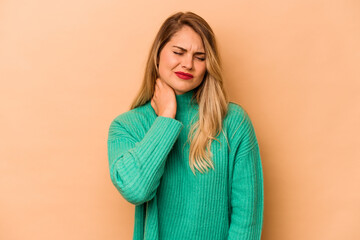 Young caucasian woman isolated on beige background having a neck pain due to stress, massaging and...