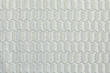 Knitted texture. Texture of jacquard fabric with gray beige geometric pattern. Crochet mosaic pattern.