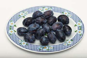 Fresh plums on plate .,