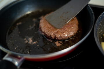 Cooking meat and fries in oily saucepan   