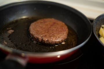 Cooking meat and fries in oily saucepan   